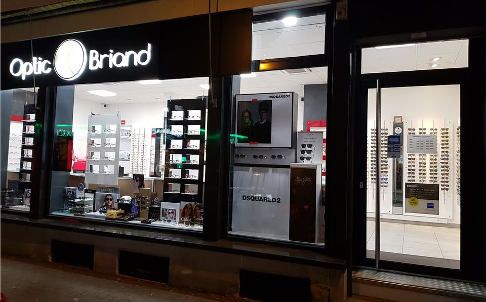 La devanture illuminée du magasin Optic Briand, avenue Aristide Briand à Mulhouse